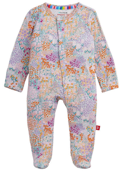 The Baby Girls’ Arabella Modal Footie by Magnetic Me features long sleeves, a vibrant floral and geometric print, and magnetic closures, shown flat on a white background.