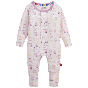 The Magnetic Me Baby Girls’ Bake Boss Modal Convertible Coverall is a long-sleeve onesie featuring a pastel food and drink pattern with bottles, cartons, and snacks on a light background, crafted from ultra-soft modal fabric for gentle comfort on delicate skin.