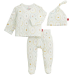The Magnetic Me Baby Nursery Magic Cream Modal Take Me Home Set includes a three-piece ensemble: a long-sleeve kimono wrap-style shirt, footed pants, and a hat, all made from soft modal fabric in white and adorned with delicate pastel animal and object prints.