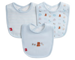 The Magnetic Me Nursery Nostalgia Modal Bib 3-Pack is displayed, featuring three eco-friendly blue baby bibs: one with stripes, one with animal illustrations, and a magnetic bib adorned with embroidered teddy bear and bow designs on the front.