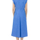 A person is shown from the back against a white background wearing the Callas Milano Miami Dress, a sleeveless knee-length stretch chambray piece, paired with black sandals.