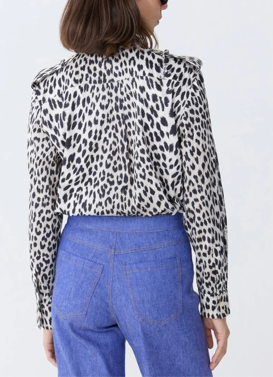 A person is shown from the back wearing the Callas Milano Mika Top, a black-and-white cheetah print shirt, paired with long-sleeve high-waisted blue jeans.