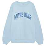 The Anine Bing Miles Sweatshirt is a pale blue, oversized crewneck pullover featuring bold "ANINE BING" lettering across the chest for a relaxed, stylish fit.