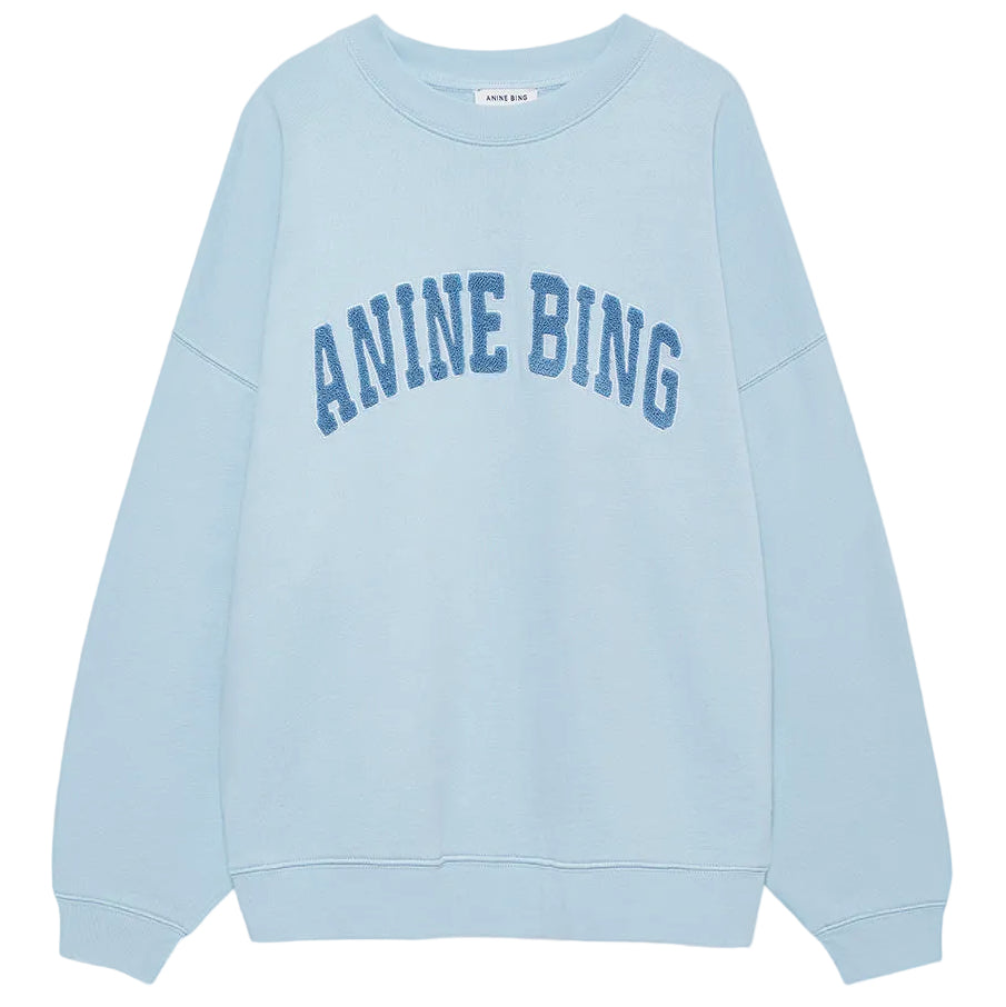 The Anine Bing Miles Sweatshirt is a pale blue, oversized crewneck pullover featuring bold "ANINE BING" lettering across the chest for a relaxed, stylish fit.