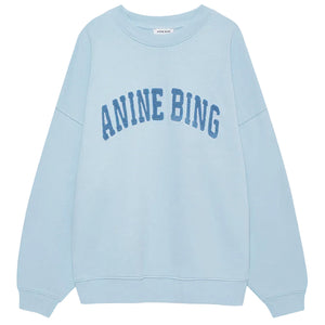 The Anine Bing Miles Sweatshirt is a pale blue, oversized crewneck pullover featuring bold "ANINE BING" lettering across the chest for a relaxed, stylish fit.