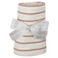 The Angel Dear Modal Rib French Stripe Misty Rose Swaddle Blanket features a rolled striped design in beige and pink hues. It's tied with a gray ribbon adorned with small white dotted lines and text. This versatile blanket is perfect for soft swaddles or as an adorable print accent in any room.