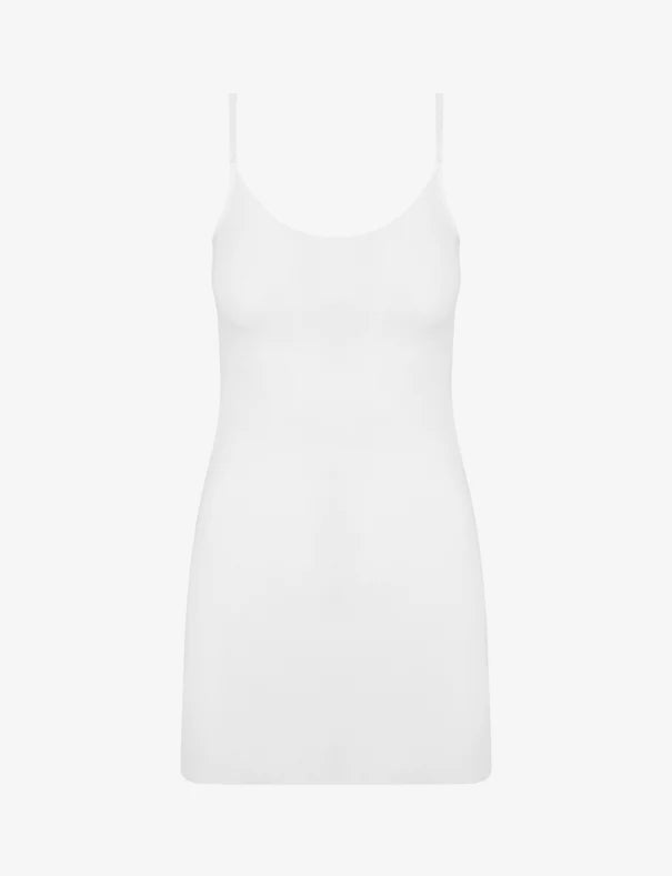 The Commando Classic Mini Cami Slip is a plain white sleeveless mini dress with thin straps and a weighted hem, perfect for layering under dresses. Shown against a white background.