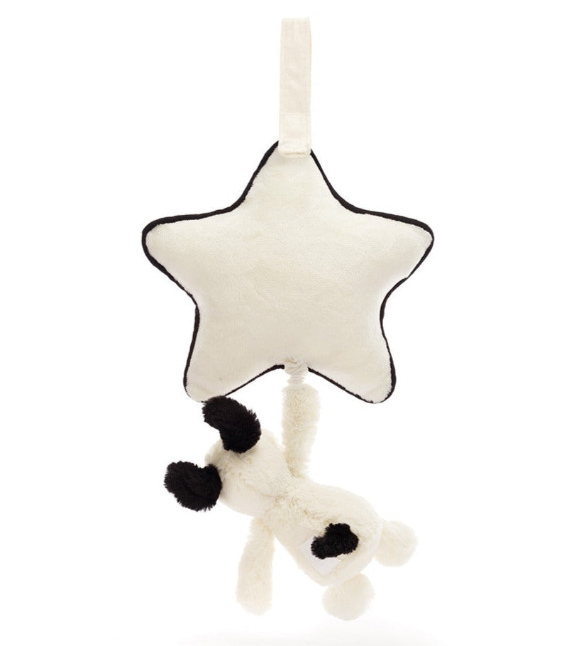 A soft star-shaped plush toy with a fabric loop at the top and a Jellycat Bashful Black & Cream Puppy Musical Pull hanging from a string attached to the bottom of the star, perfect for comforting your newborn.