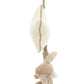 A plush toy featuring a Jellycat Bashful Beige Bunny Musical Pull hanging from a soft, cream-colored textured object, attached by a fabric loop, perfect for enjoying a Jellycat lullaby.