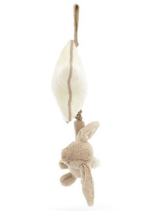 A plush toy featuring a Jellycat Bashful Beige Bunny Musical Pull hanging from a soft, cream-colored textured object, attached by a fabric loop, perfect for enjoying a Jellycat lullaby.