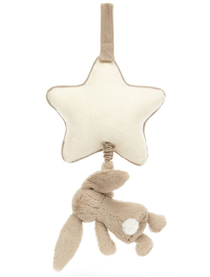 Jellycat Bashful Beige Bunny Musical Pull toy with beige fabrics; the bunny hangs upside-down from a loop attached to the bottom of the star, creating a sweet Jellycat lullaby for little ones.