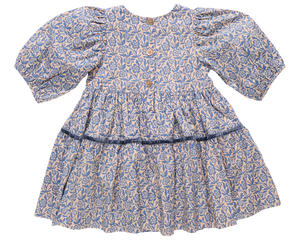 The Girls' Maribelle Dress by Pink Chicken showcases a blue climbing floral print on cotton poplin, puff sleeves, three wooden back buttons, and a gathered skirt with a dark blue ribbon at the waist.