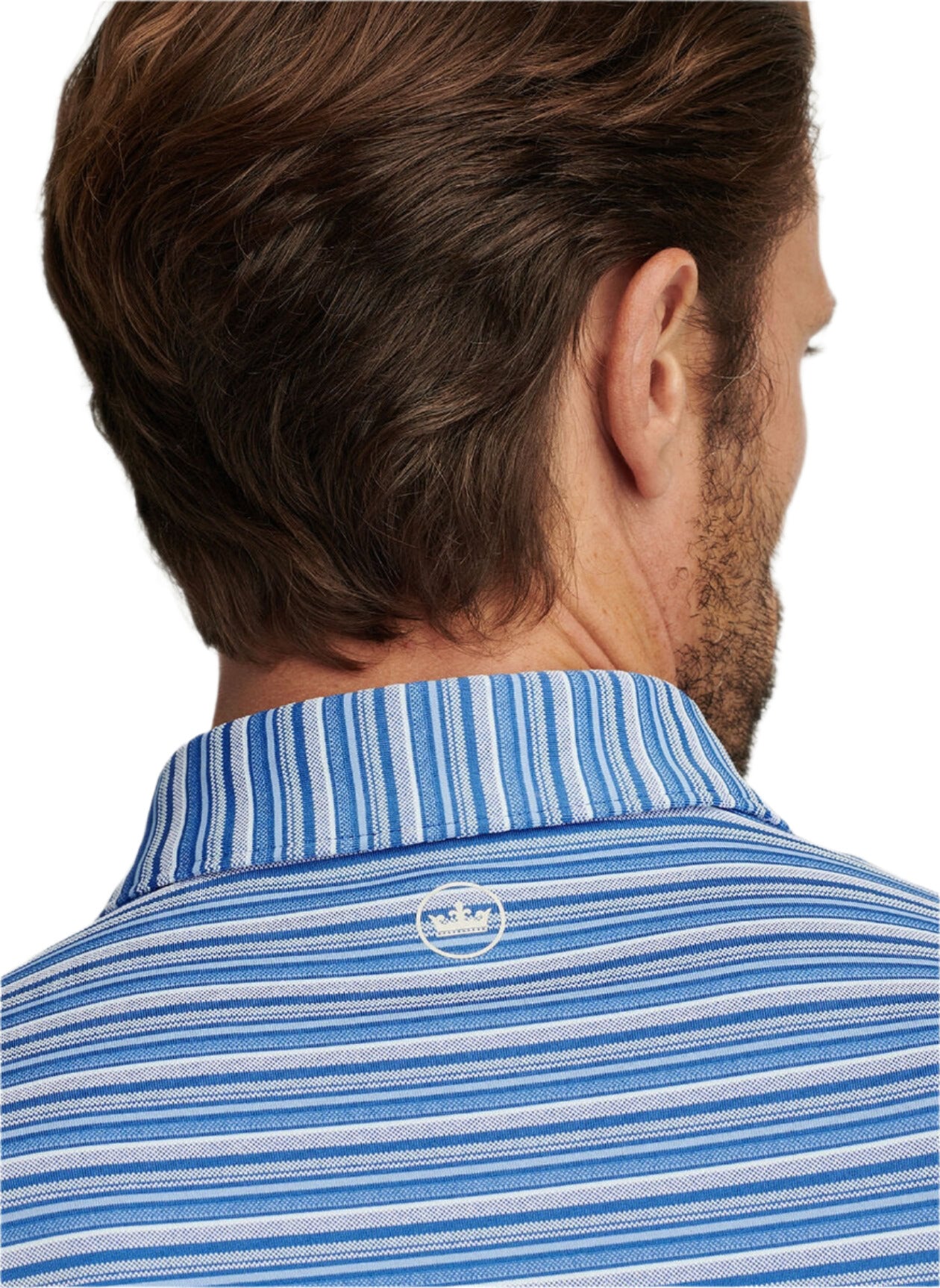 A man is seen from behind wearing the Peter Millar Atrium Performance Jersey Polo, designed with Summer Comfort fabric in blue and white stripes and finished with a small white logo on the upper back.