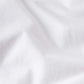 Close-up of white Supima cotton fabric with soft folds and gentle shadows, highlighting the luxurious feel of the Frame Light Cotton Tee—perfect for lightweight comfort and everyday style.