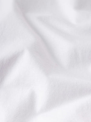 Close-up of white Supima cotton fabric with soft folds and gentle shadows, highlighting the luxurious feel of the Frame Light Cotton Tee—perfect for lightweight comfort and everyday style.