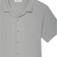 The Jacquard Short Sleeve Relaxed Shirt by Frame is a light grey men's shirt in textured cotton, featuring a notched collar, chest pocket, and an inner "FRAME" label.
