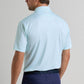 A man is shown from the back wearing a light blue Peter Millar Ashgrove Performance Jersey Polo and dark blue pants against a plain background.