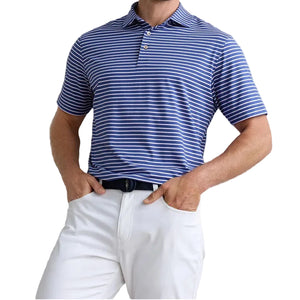 A man wears the Peter Millar Dunnes Performance Jersey Polo, featuring blue and white stripes and four-way stretch, tucked into white pants with a black belt.