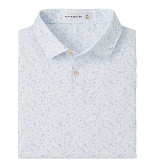 The Peter Millar Featherweight Land Of The Free Performance Polo in light blue features a subtle floral print, four-way stretch for comfort, and is neatly folded with its collar and buttons visible.