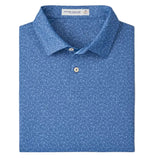 A Peter Millar Featherweight Headcovers Performance Polo in blue with a subtle white dotted pattern, four-way stretch, neatly folded with the collar and buttons visible.