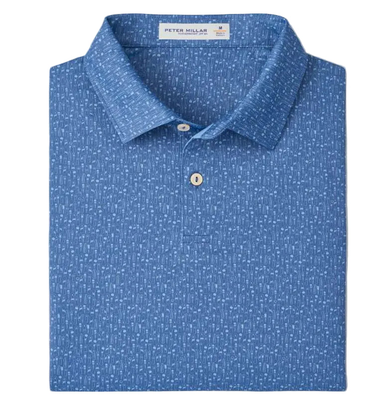 A Peter Millar Featherweight Headcovers Performance Polo in blue with a subtle white dotted pattern, four-way stretch, neatly folded with the collar and buttons visible.