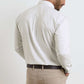 A man stands facing away, wearing the Peter Millar Douglas Crown Lite Cotton-Stretch Sport Shirt in a light plaid, tucked into beige pants with a dark brown belt.