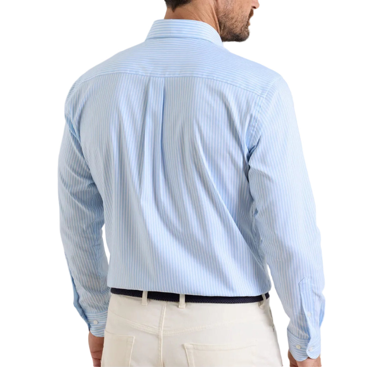 A man is seen from the back wearing the Peter Millar Langley Crown Lite Cotton-Stretch Sport Shirt in light blue stripes with beige pants.