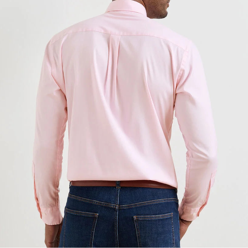 A man is seen from the back against a plain background, wearing the Peter Millar Campbell Sport Shirt in light pink cotton Oxford and dark blue jeans.