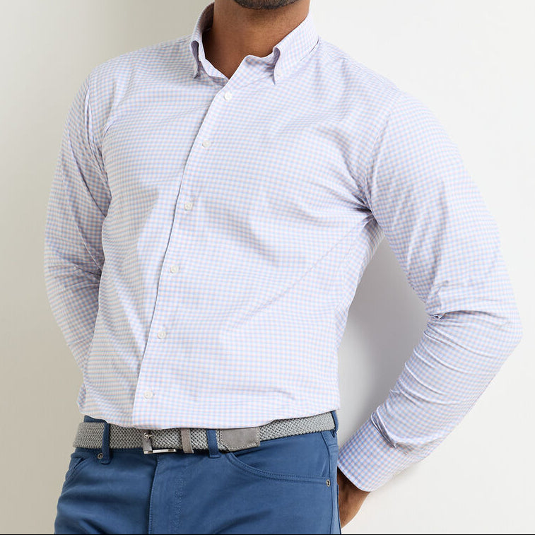 A person wears the Peter Millar Gregory Performance Twill Sport Shirt in light blue checks, tucked into blue pants with a textured grey belt, standing against a white background.