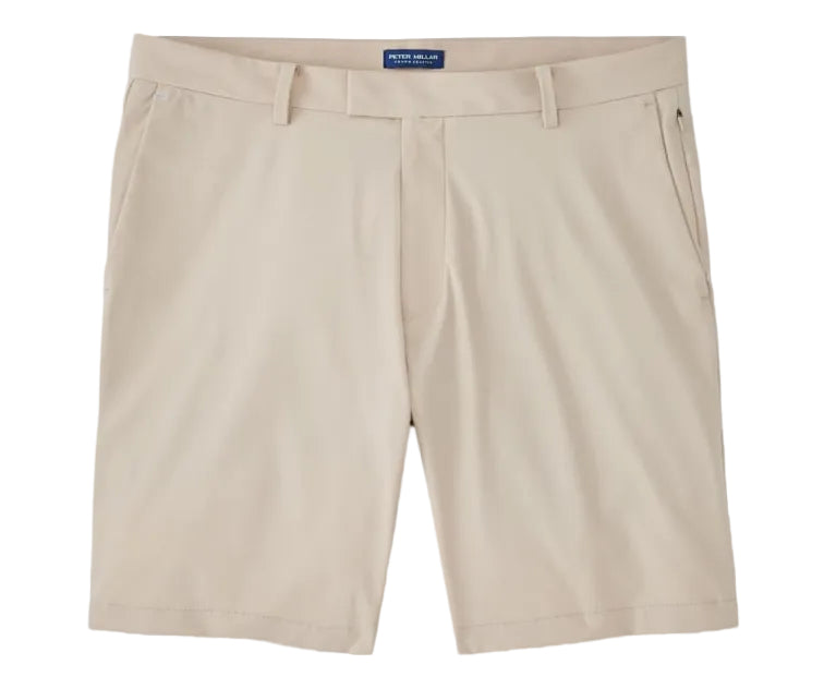 The Bingham Performance Short by Peter Millar in beige is a wrinkle-resistant, knee-length style featuring belt loops, front pockets, and a zipper fly, shown laid flat on a white background.