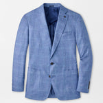 The Reynolds Plaid Soft Jacket by Peter Millar is a European-crafted, light blue plaid wool blazer with notch lapels, front pockets, and two buttons, shown laid flat on a white background.