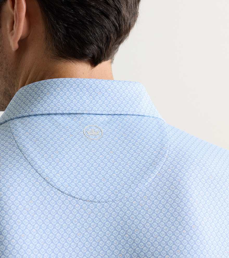 Close-up of the back of a man's neck and shoulders wearing the Peter Millar Mayfield Performance Jersey Polo in light blue pattern, featuring a small circular collar logo and offering UPF 50+ sun protection.