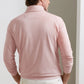 A man, seen from behind in a minimal indoor setting, wears the Peter Millar Albatross Cotton-Blend Piqué Quarter-Zip in light pink paired with white pants.