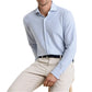 A man wearing the Peter Millar Excursionist Flex Stripe Sport Shirt and beige pants sits on a wooden stool against a white background.
