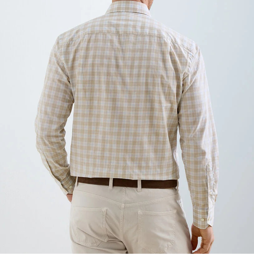 Shown from behind, a person wears the Peter Millar Venzone Italian Poplin Sport Shirt in beige plaid with long sleeves, cropped at the back, paired with light-colored pants.