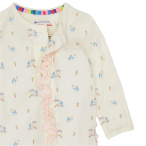 The Magnetic Me Baby Girls' Modal Footie with Ruffle is a cream long-sleeve romper featuring colorful prints, ruffled trim, and a multicolored neckline. Made from soft, temperature-regulating TENCEL™ modal, with an "eco-friendly" label inside the collar.