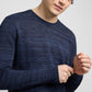 A person adjusts the sleeve of an Onia Silk Linen Crewneck in dark blue, cropped at the mouth and above the waist, against a plain light background—a perfect everyday knit.