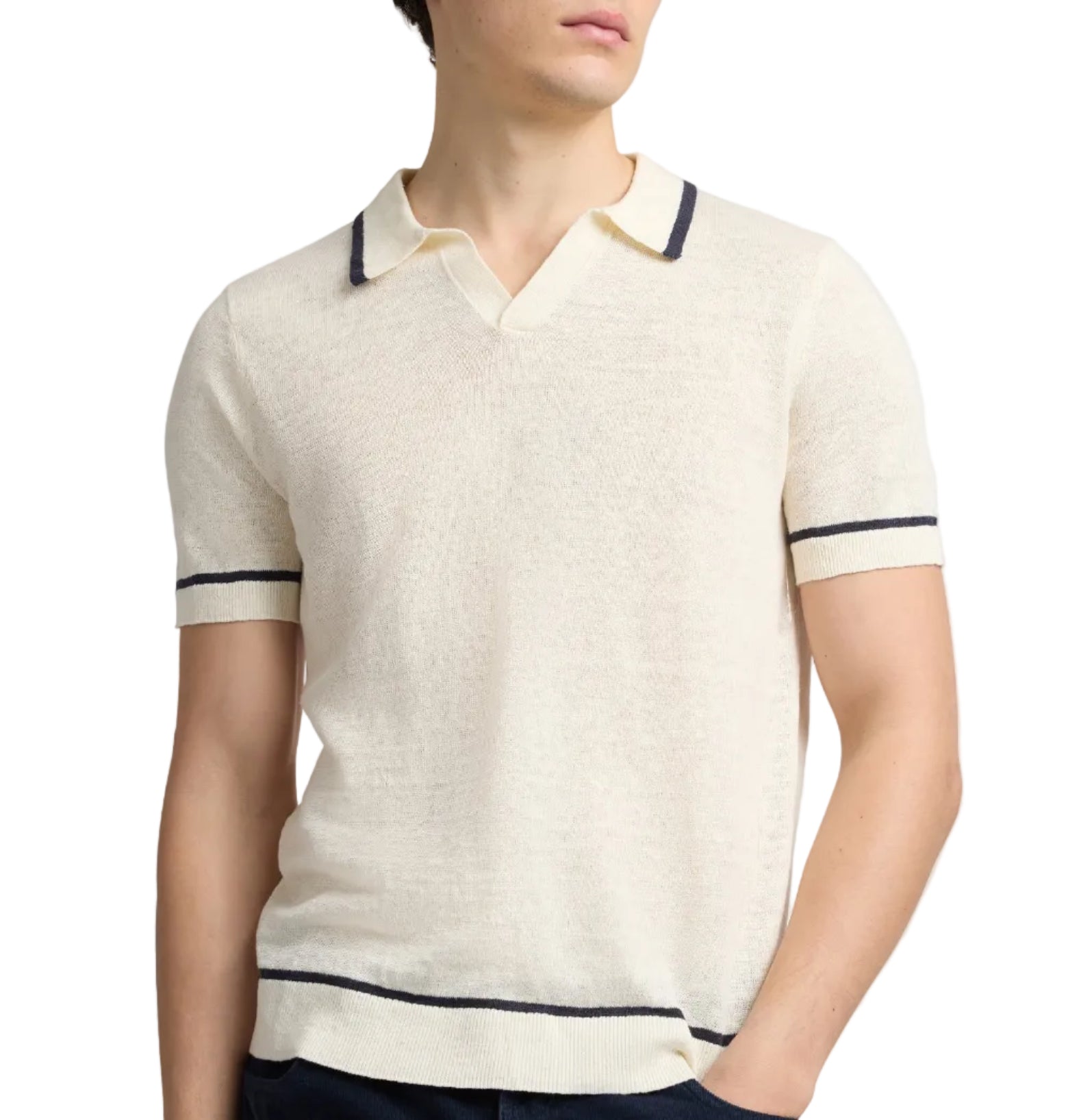 A man wearing the Onia Linen Johnny Collar Polo Sweater—a short-sleeve cream knit with dark trim—stands with one hand in his pocket.