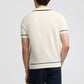 A person shown from the back wears the Onia Linen Johnny Collar Polo Sweater, a short-sleeve off-white knit with dark trim, paired with dark pants against a plain background.