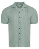 The Linen Pintuck Camp Shirt by Onia is a light green, pure linen short-sleeve shirt featuring a chest pocket and vertical pintuck pleats on the front.