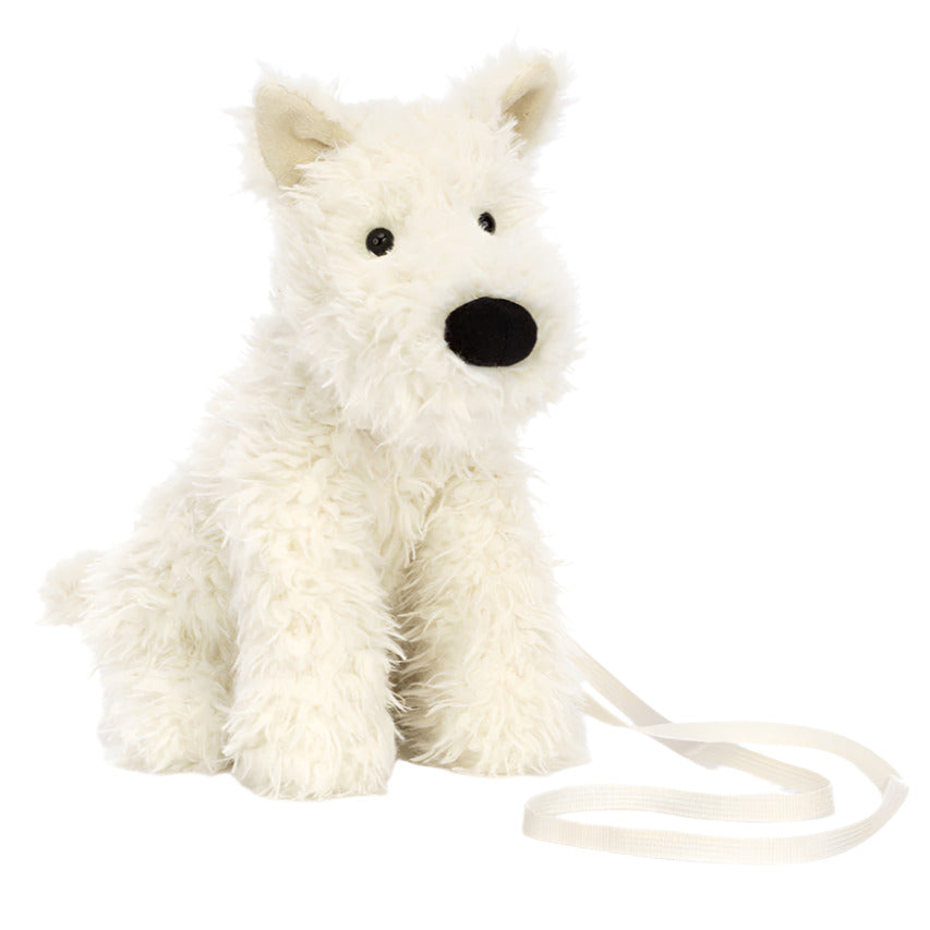 The Jellycat Munro Scottie Dog Bag features pointy ears, a black nose, and a cream-colored strap—perfect for adventure-seekers. This plush accessory sits upright against a white background, blending playful charm with functionality.