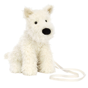 The Jellycat Munro Scottie Dog Bag features pointy ears, a black nose, and a cream-colored strap—perfect for adventure-seekers. This plush accessory sits upright against a white background, blending playful charm with functionality.
