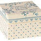 A cream-colored, square Maileg keepsake box adorned with blue floral and polka dot patterns, featuring elegant French text on the lid. Perfect for storing Maileg Macarons et Chocolat Chaud or treasures from your Maileg Friends collection.