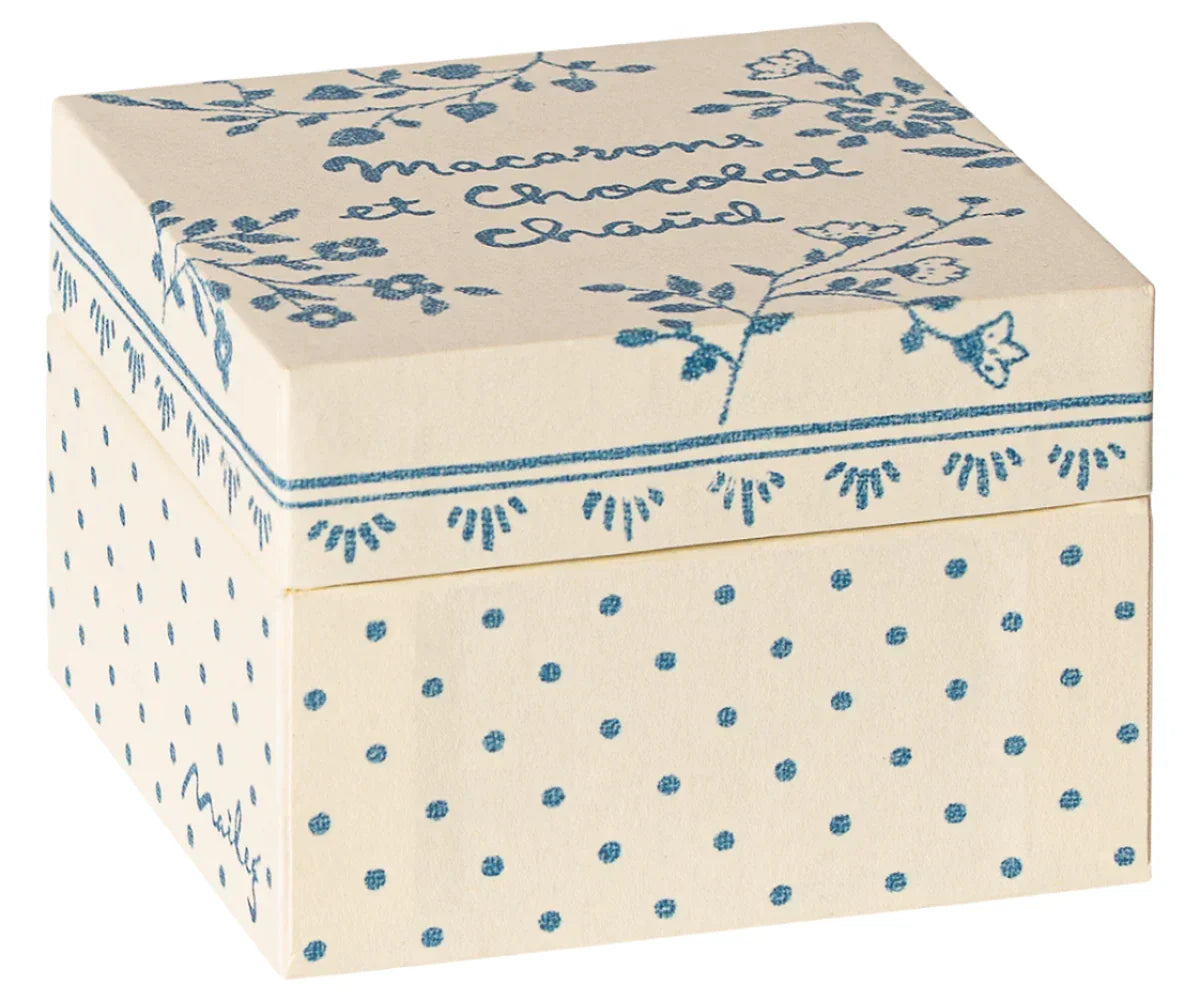 A cream-colored, square Maileg keepsake box adorned with blue floral and polka dot patterns, featuring elegant French text on the lid. Perfect for storing Maileg Macarons et Chocolat Chaud or treasures from your Maileg Friends collection.