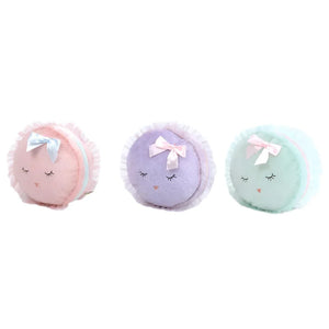 Introducing the MON AMI Le Macarons by Mon Ami: a set of three round, plush toys in delightful pastel hues—pink, lavender, and mint green—featuring closed eyes and charming ribbon bows on top, evoking the elegance of macarons at a tea party.