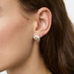 Close-up of a person's ear wearing chunky, sculpted Lie Studio Magda Earrings in sterling silver. The person has long brown hair and a dark top, evoking vintage silhouettes.
