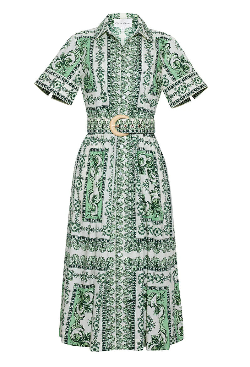 The Malena Dress by Cara Cara features a green and white pattern, short sleeves, a collared neckline, and a matching belt with a circular buckle for a flattering fit-and-flare silhouette.