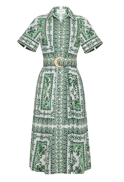The Malena Dress by Cara Cara features a green and white pattern, short sleeves, a collared neckline, and a matching belt with a circular buckle for a flattering fit-and-flare silhouette.