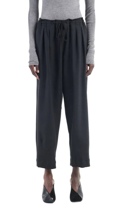A person wearing a gray ribbed long-sleeve top, Maria McManus Barrel Leg Drawstring Trouser in black Japanese cotton, and black open-toe heels, shown from shoulders to feet.