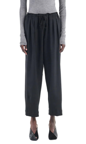 A person wearing a gray ribbed long-sleeve top, Maria McManus Barrel Leg Drawstring Trouser in black Japanese cotton, and black open-toe heels, shown from shoulders to feet.